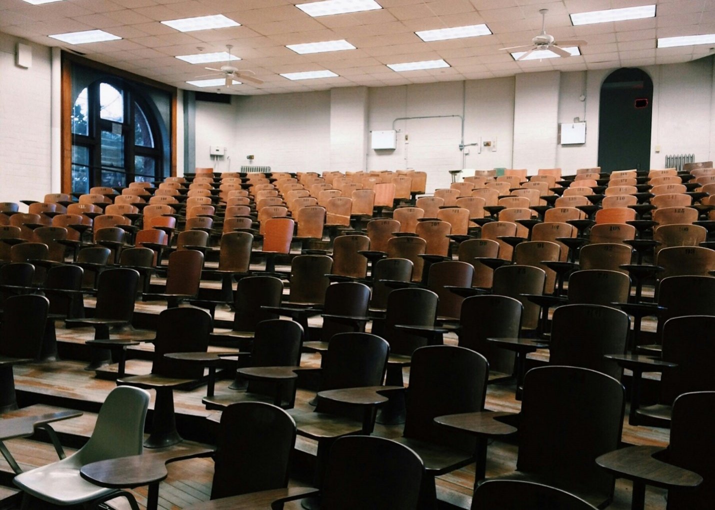 A large space filled with chairs with small desk attachments like a school auditorium visited by electromagnetic field testing consultants in New Jersey